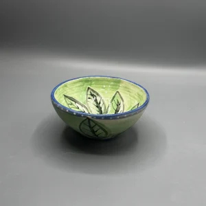 The soft green interior and deep cobalt rim give this piece a calm, reflective presence.