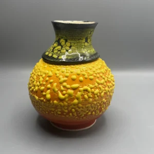 A layered surface caught between eruption and stillness — glowing yellows and volcanic tones suggest emotional heat carried beneath the surface. (view 2 of 4)